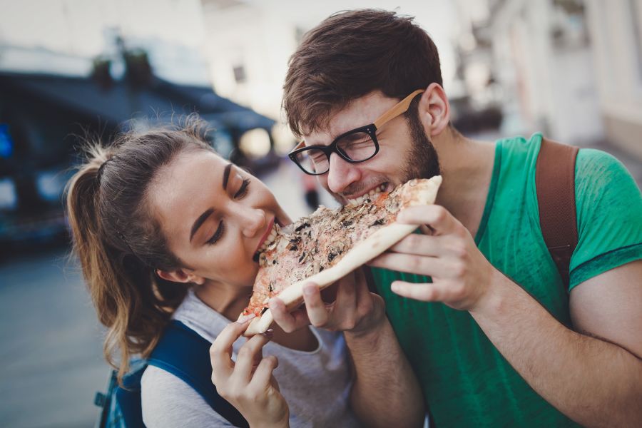 Glueckliches Paar isst zusammen Pizza